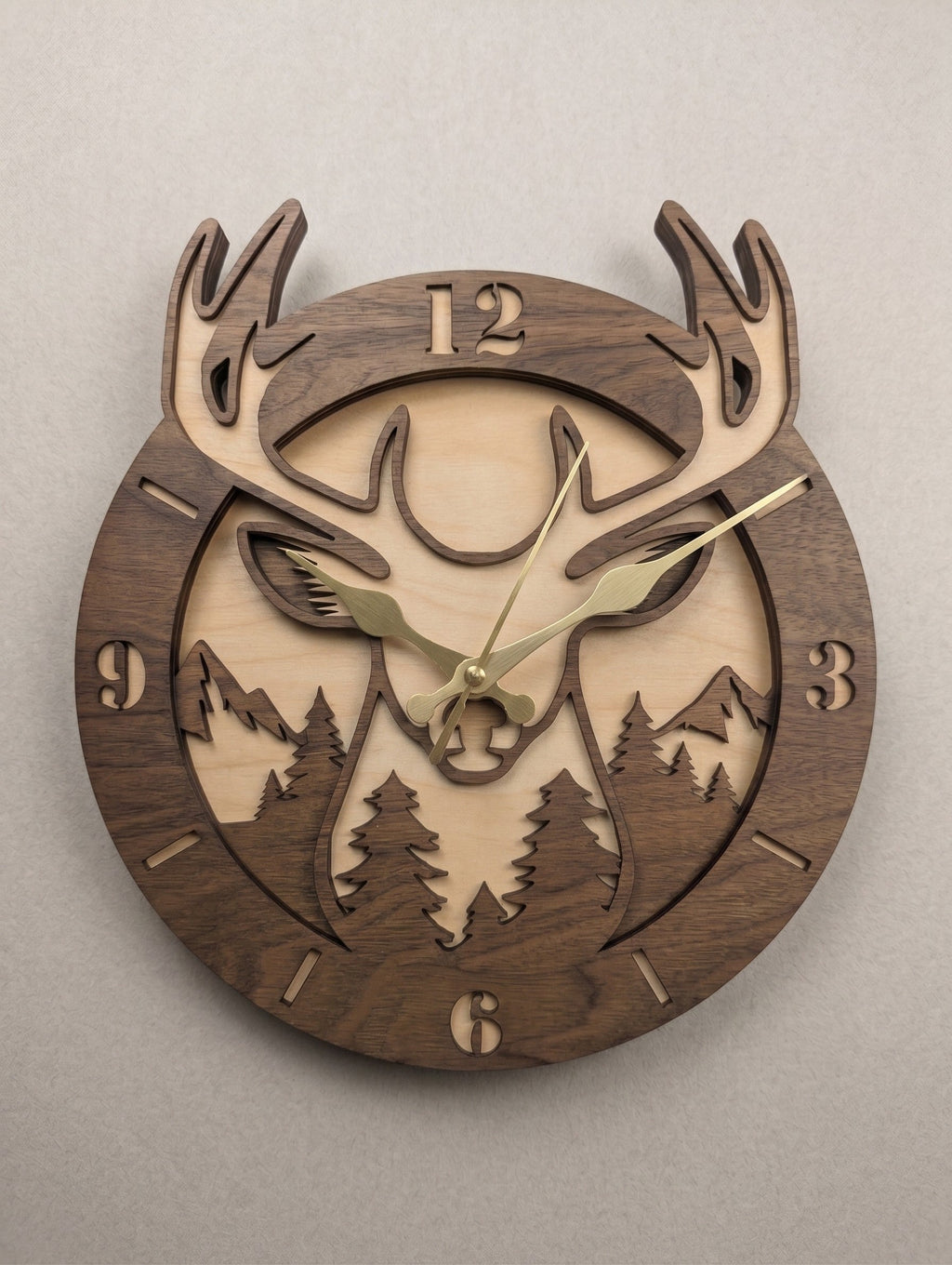 Seime-Kreativschuppen 3D-Wanduhr Waldkönig aus Walnuss und Linde mit Hirschmotiv, Berglandschaft und goldenen Zeigern.