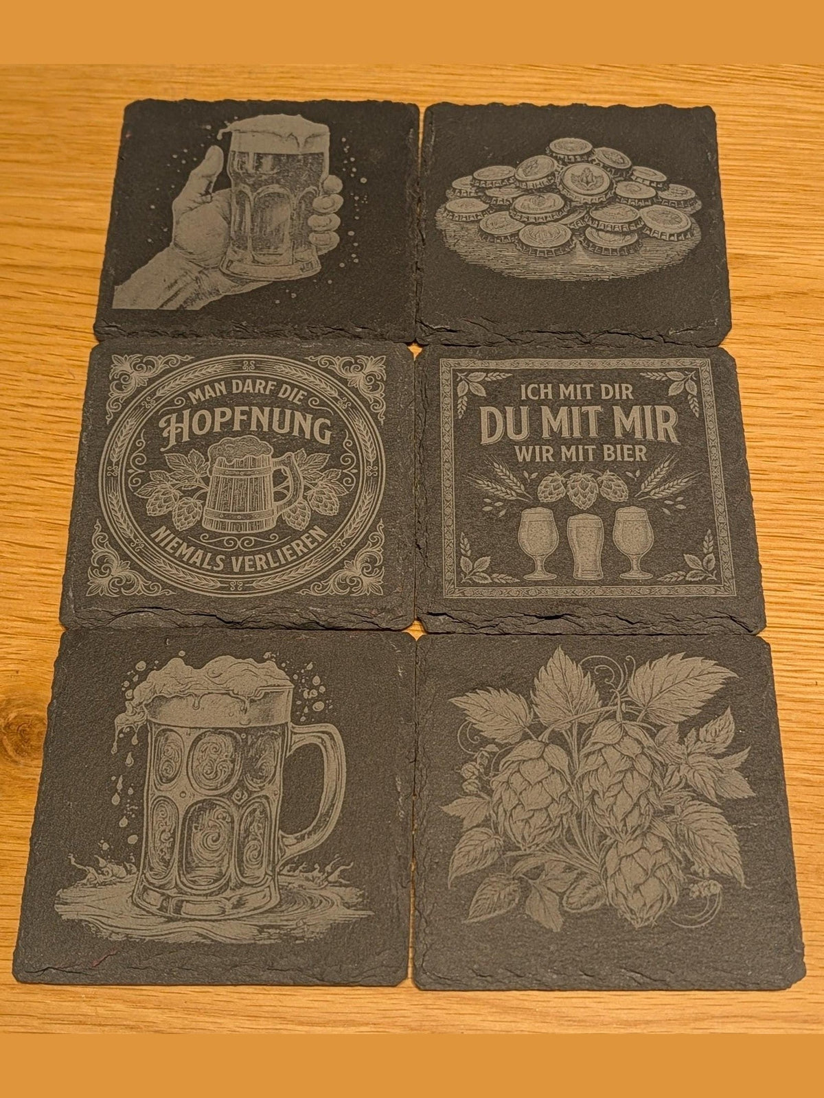 Seime-Kreativschuppen 6er-Set quadratische Schiefer-Untersetzer mit Bier-Gravuren auf einem Holztisch